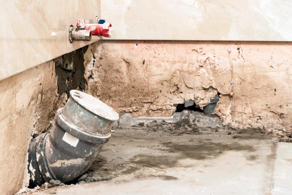 Water damage and pipe leak repair in a residential wall.