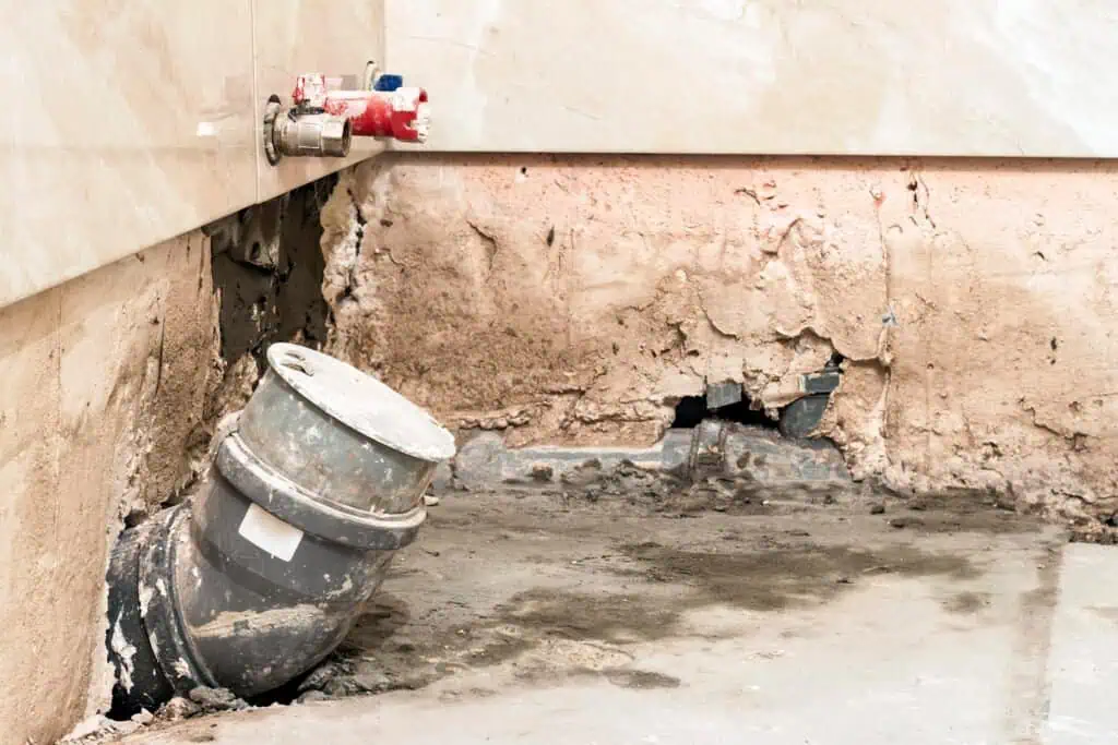 Water damage and pipe leak repair in a residential wall.